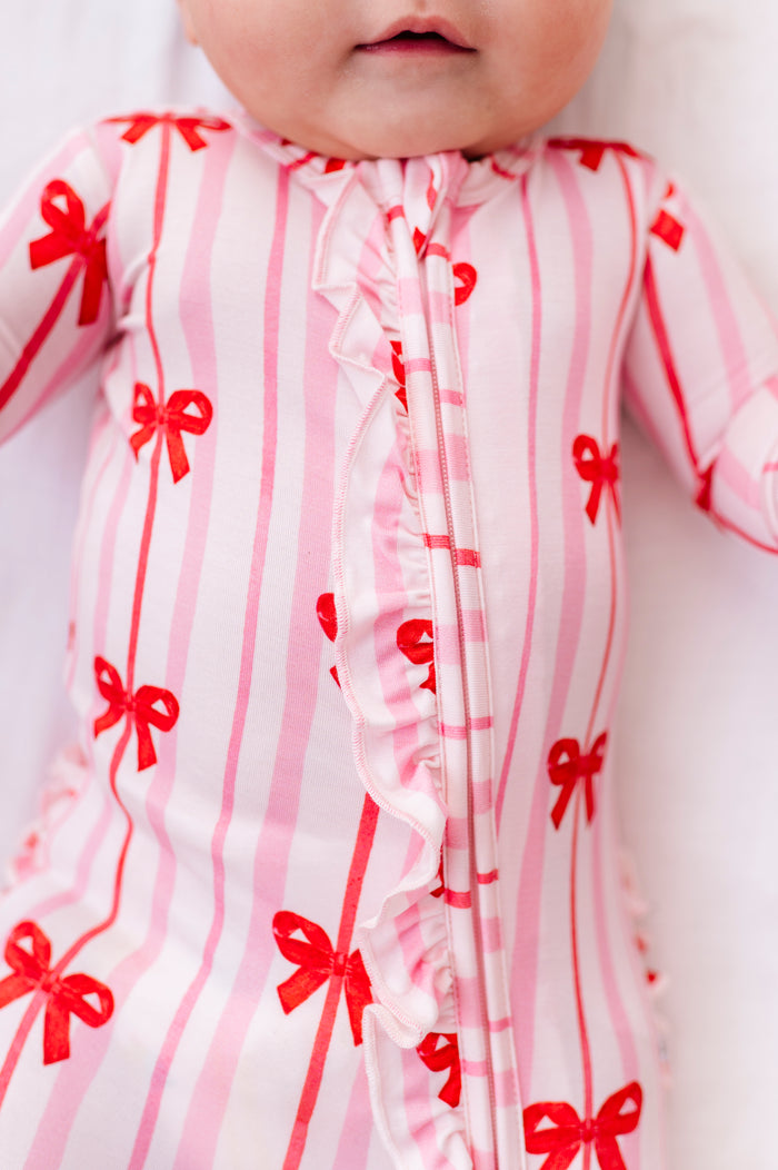 Close-up of Ruby Ribbons bamboo romper with ruffle zipper detail and bow print