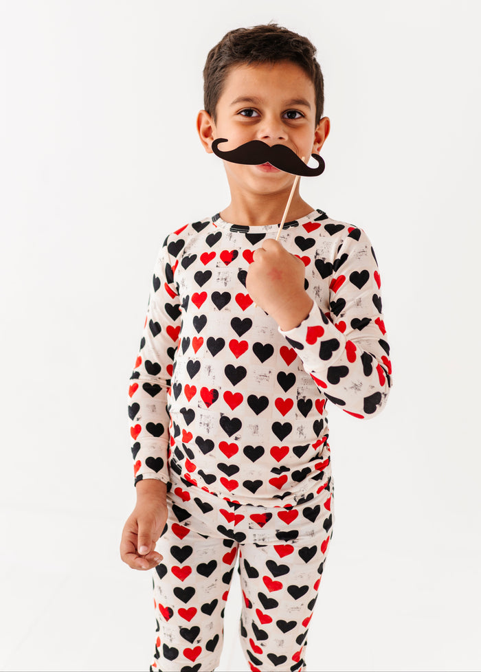 Child wearing King of Hearts bamboo pajama set with red and black heart print