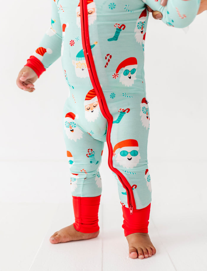Child wearing a Christmas-themed bamboo zip romper with red accents on a white background