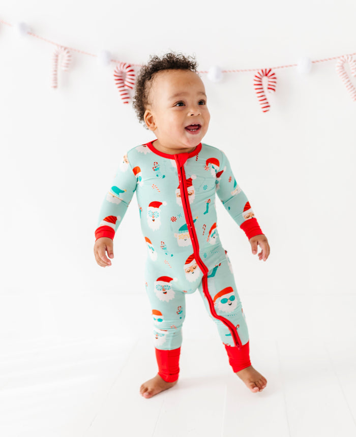 Baby wearing a Christmas bamboo onesie with Santa Claus design on a white background