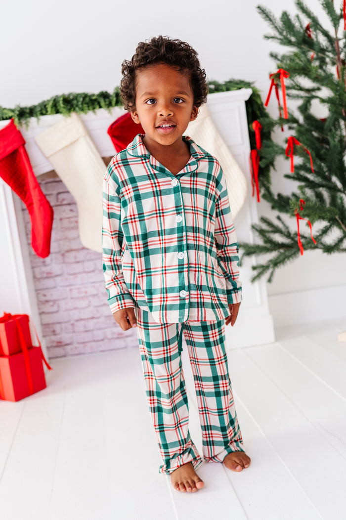 A little boy wearing a classic Christmas plaid print in red, green, and cream