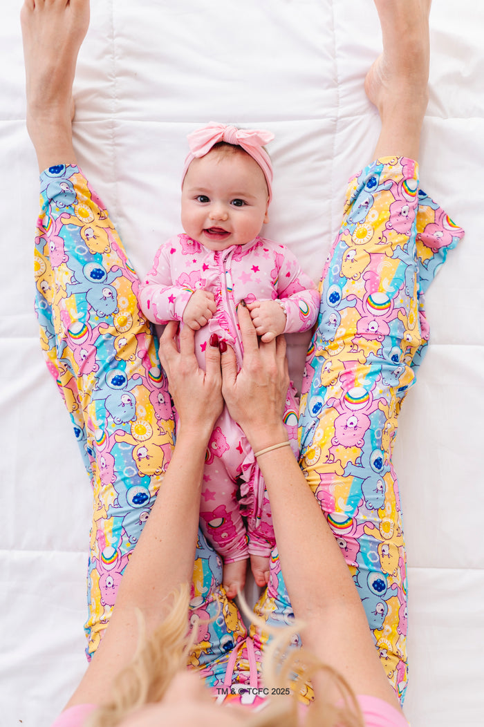 Mom wearing Care Bears Stare bamboo pajama set holding baby in matching Care Bears outfit