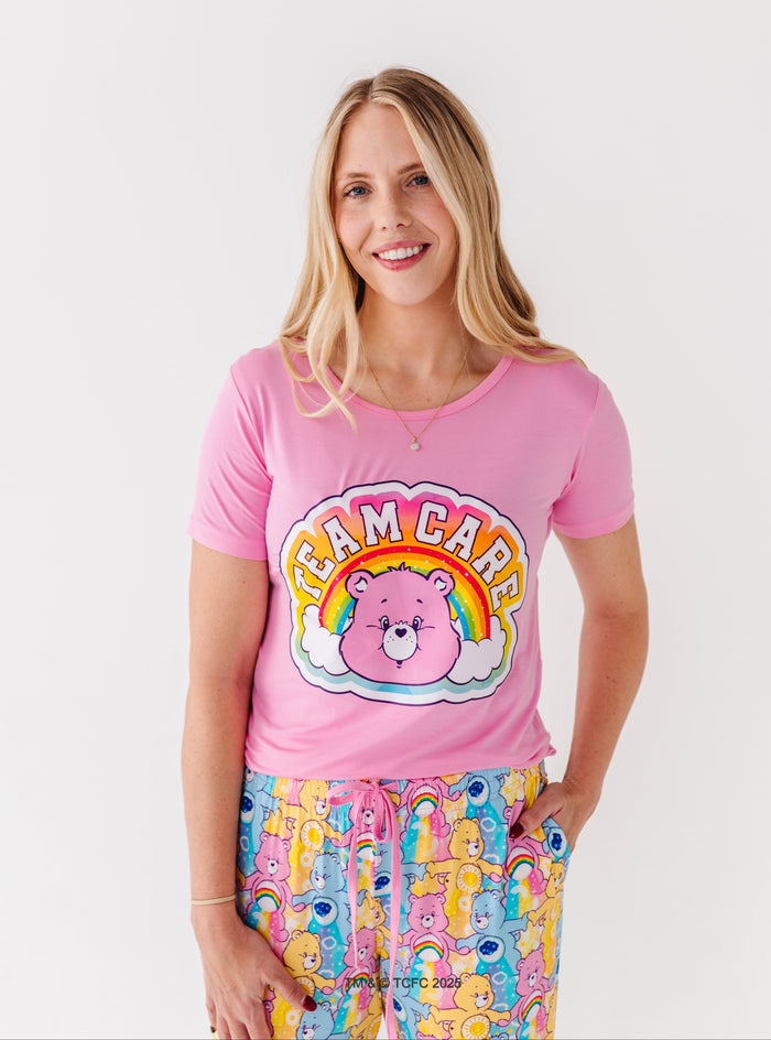 Woman wearing pink Care Bears bamboo tee with rainbow bear design and bamboo lounge pants