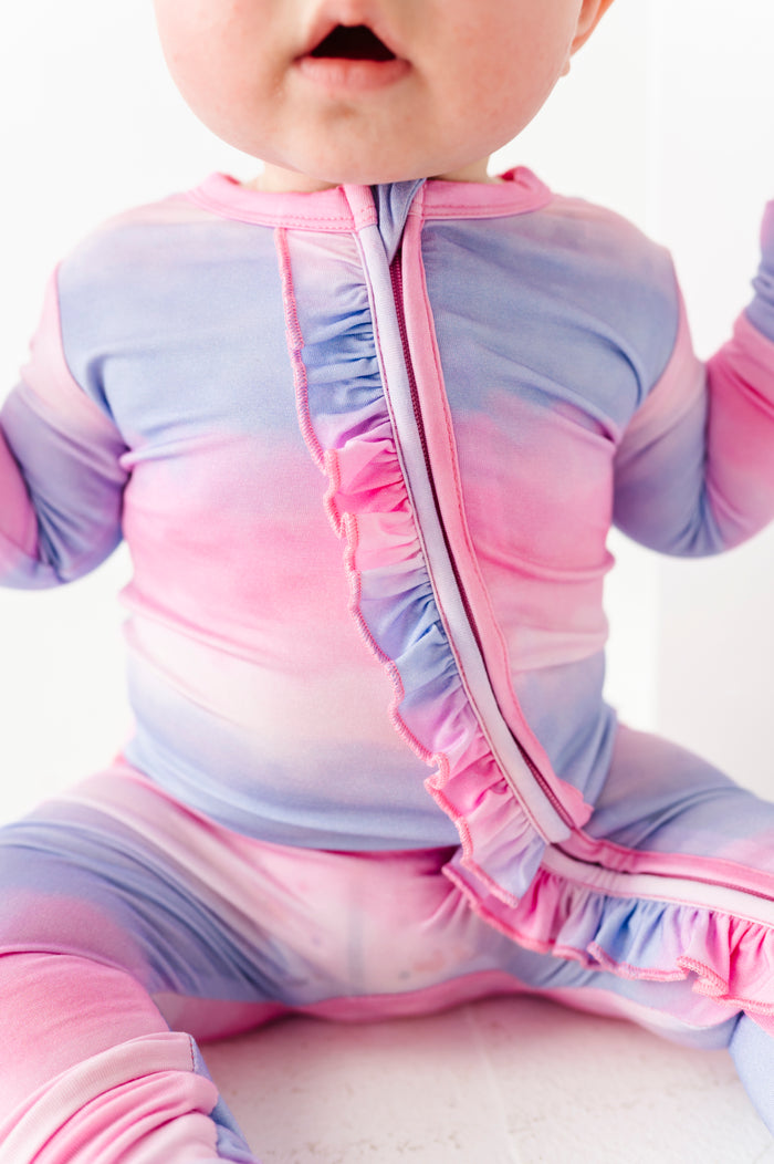 Baby in a colorful bamboo onesie with a white background