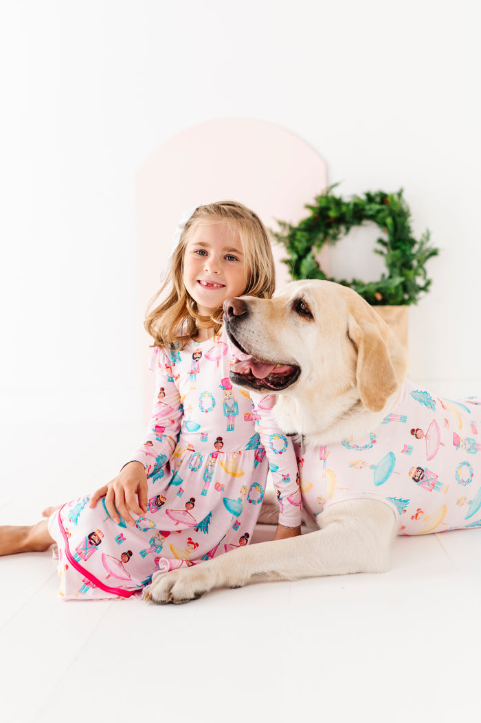 Girl and dog wearing matching bamboo Christmas outfits on a white background