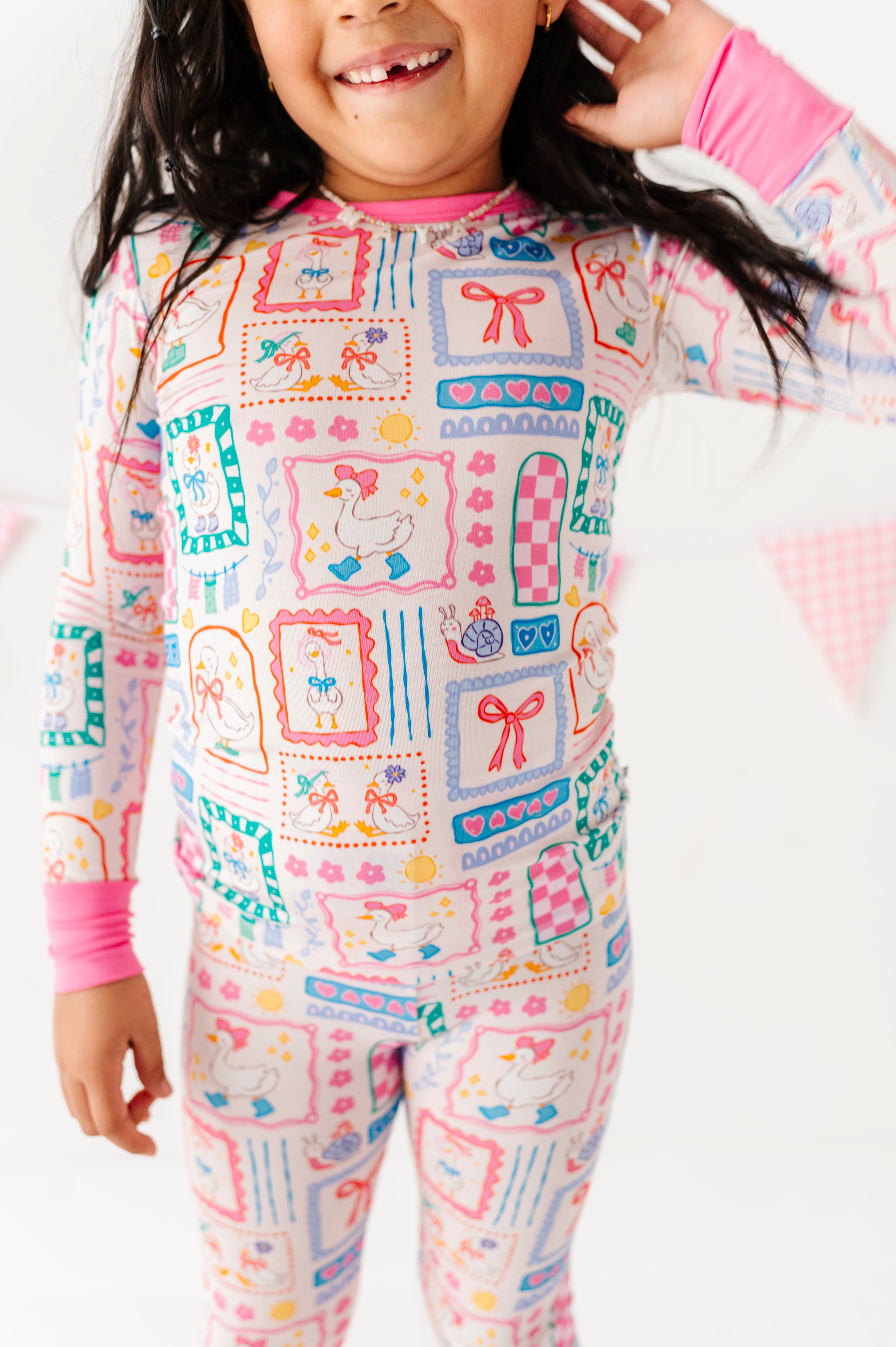 Little girl wearing a Gilly Goose bamboo two-piece set against a white background