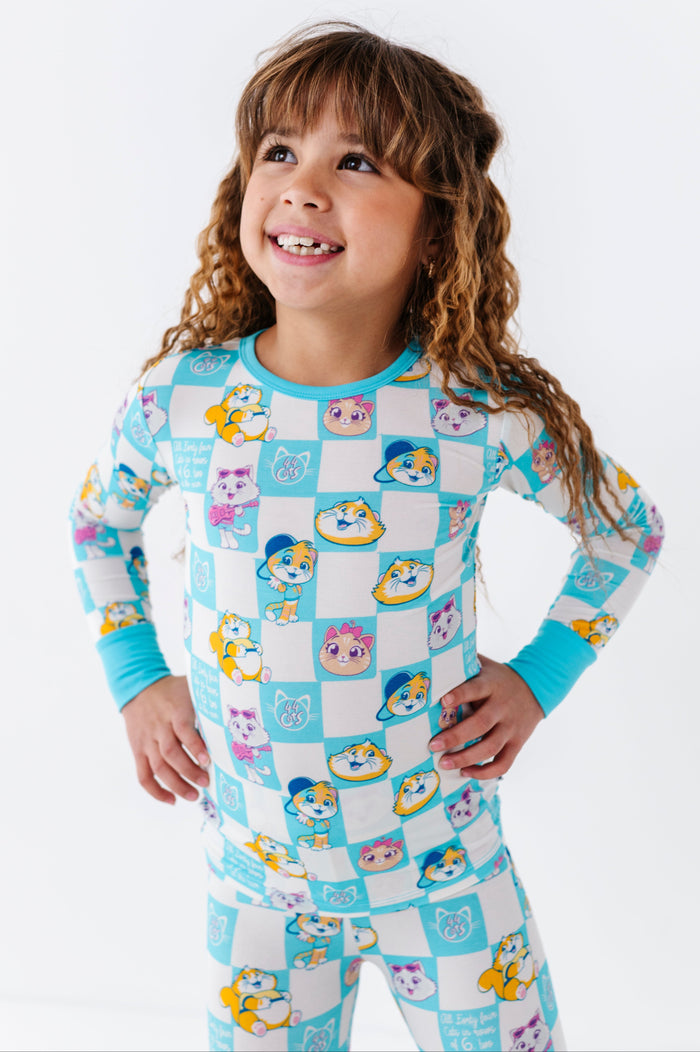 Child wearing a colorful 44 Cats™ pajama set with cartoon characters on a white background