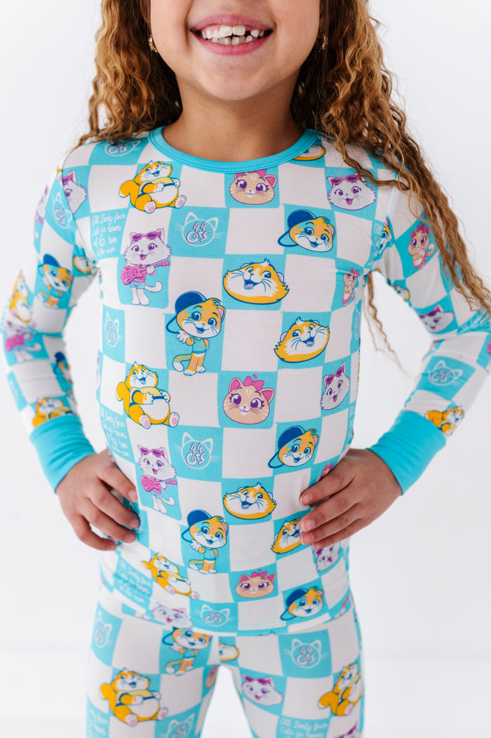 Child wearing a 44 Cats™ pajama set with cartoon character cats on a white background
