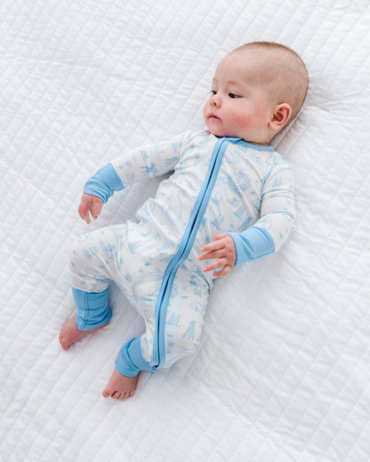 Baby in a blue and white bamboo Easter onesie lying on a textured white surface