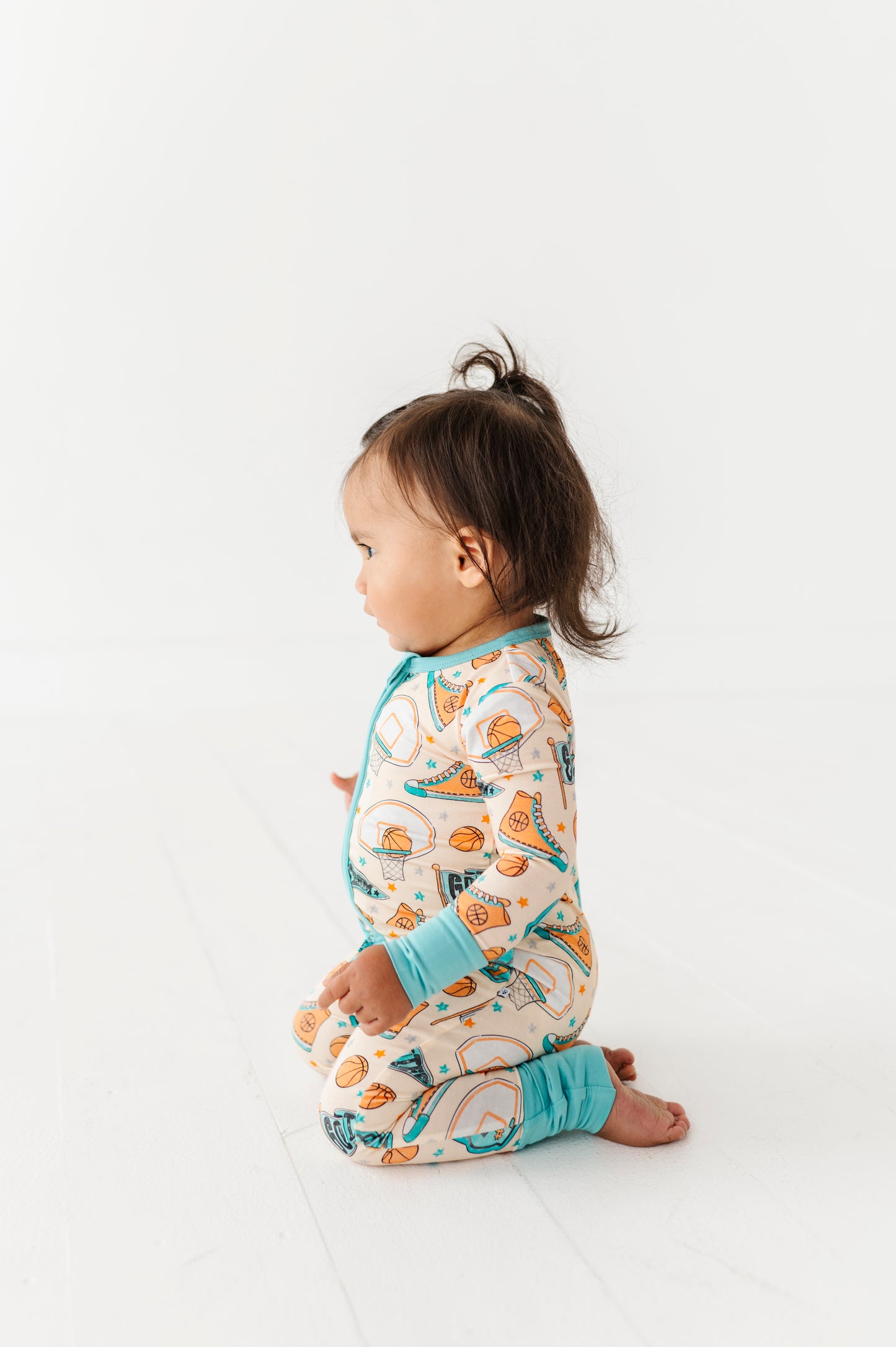 Child wearing a basketball bamboo onesie on a white background