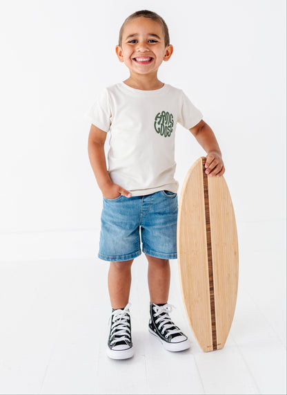 Child holding a wooden surfboard on a white background