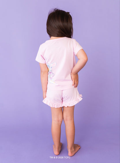 Child wearing a lilac Care Bears™ outfit on a purple background