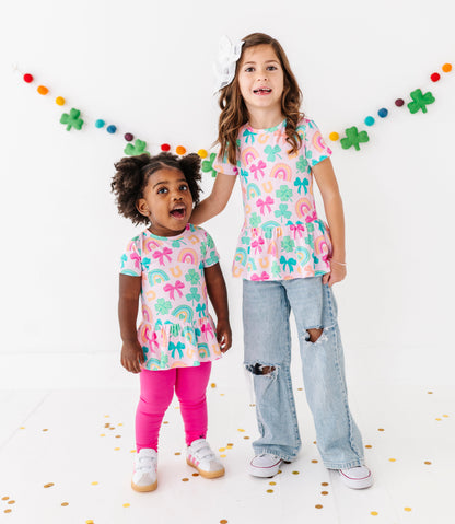Two children wearing matching St. Patrick's Day bamboo cotton tops with colorful confetti on a white background