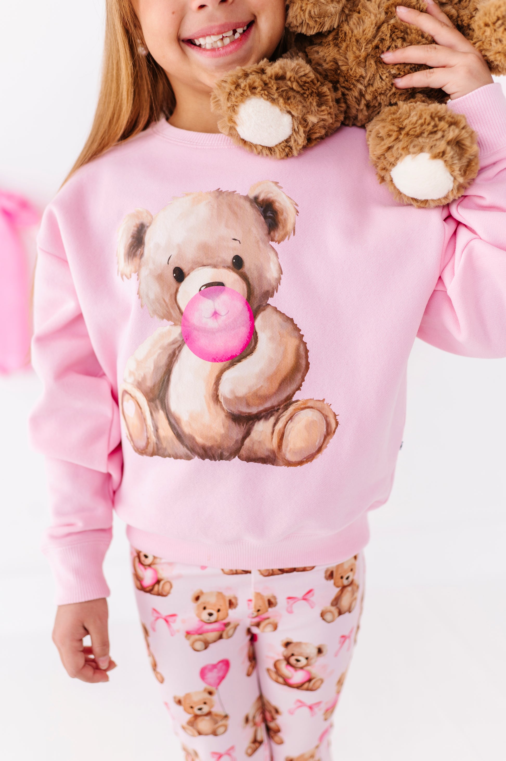 Close-up of teddy bear graphic on pink Valentine’s Day sweatshirt for kids