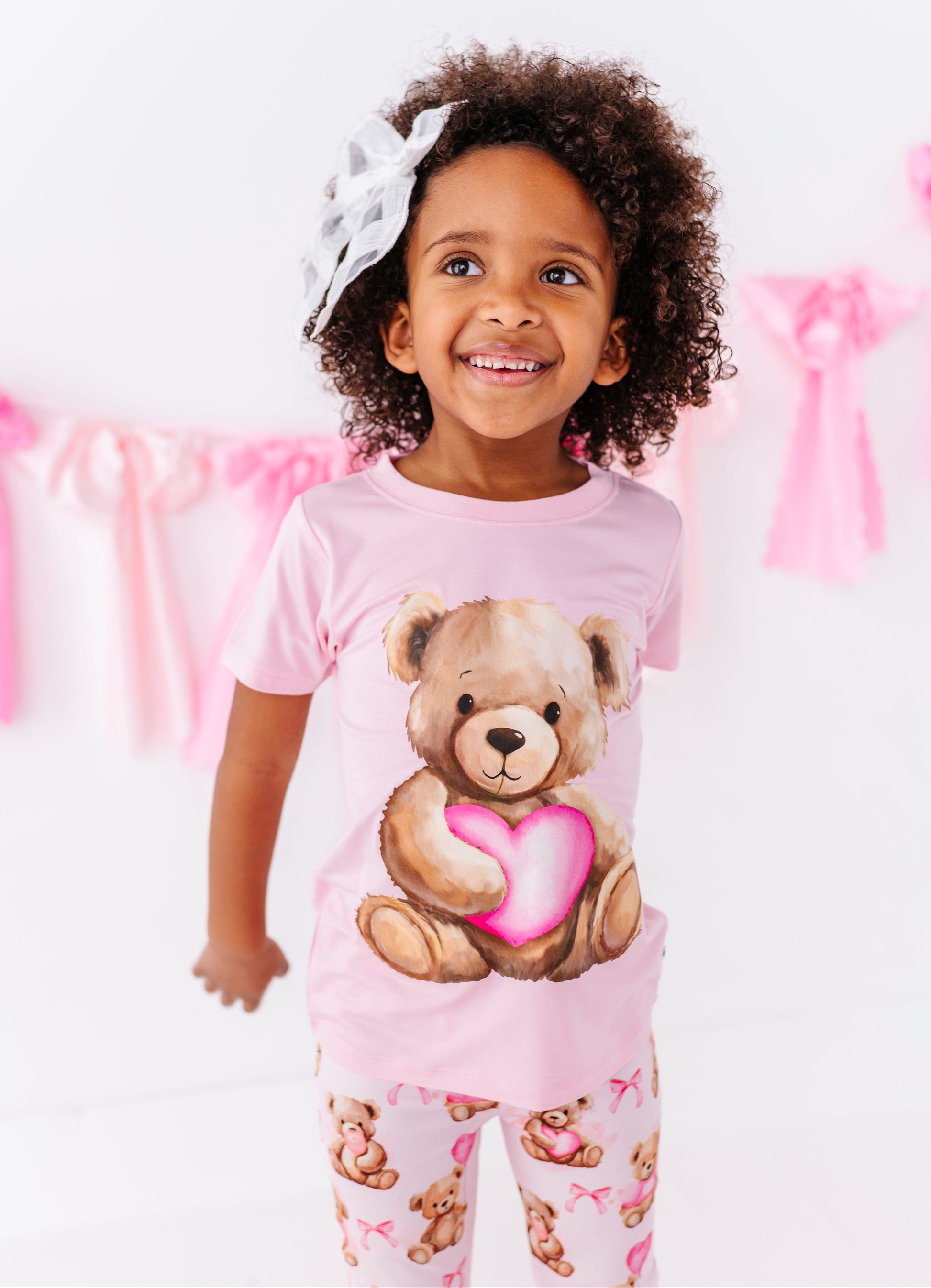 Pink bamboo kids t-shirt with teddy bear heart graphic shown from the front