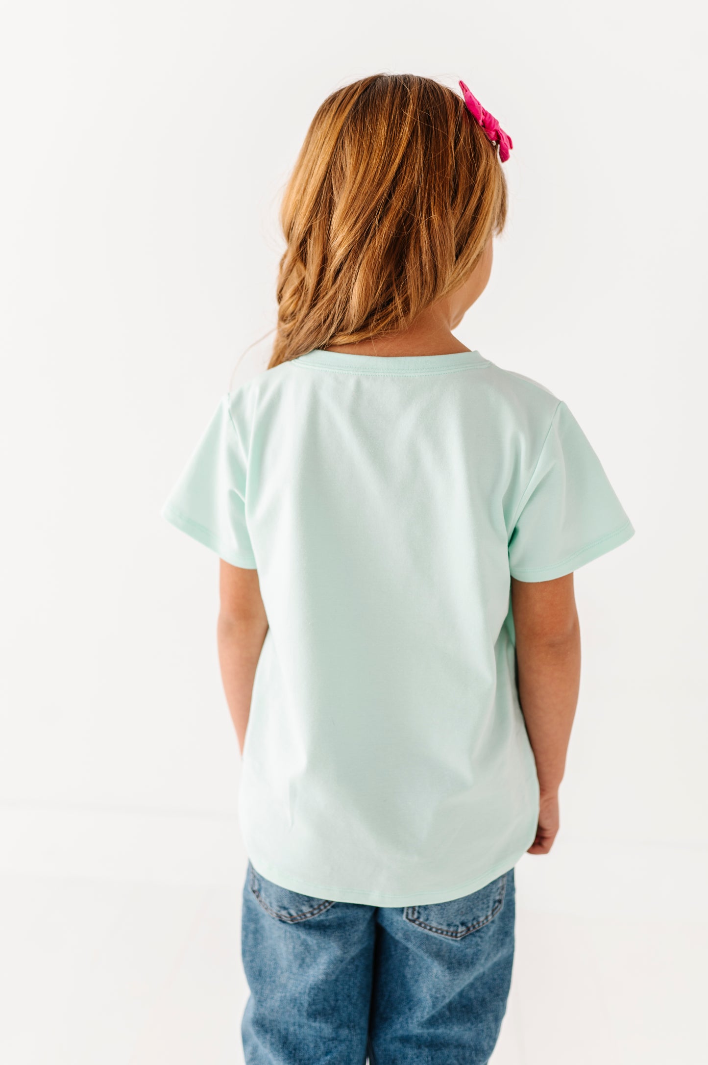 Back view of mint green children’s t-shirt showing smooth lightweight fabric and relaxed fit
