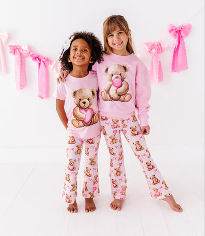 Pink kids pants featuring hand painted teddy bear and heart pattern