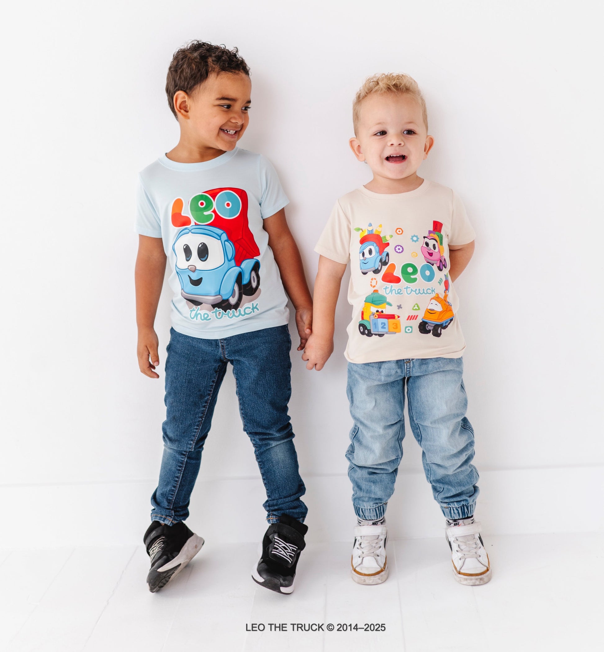 Two children wearing Leo the Truck bamboo t-shirts on a white background