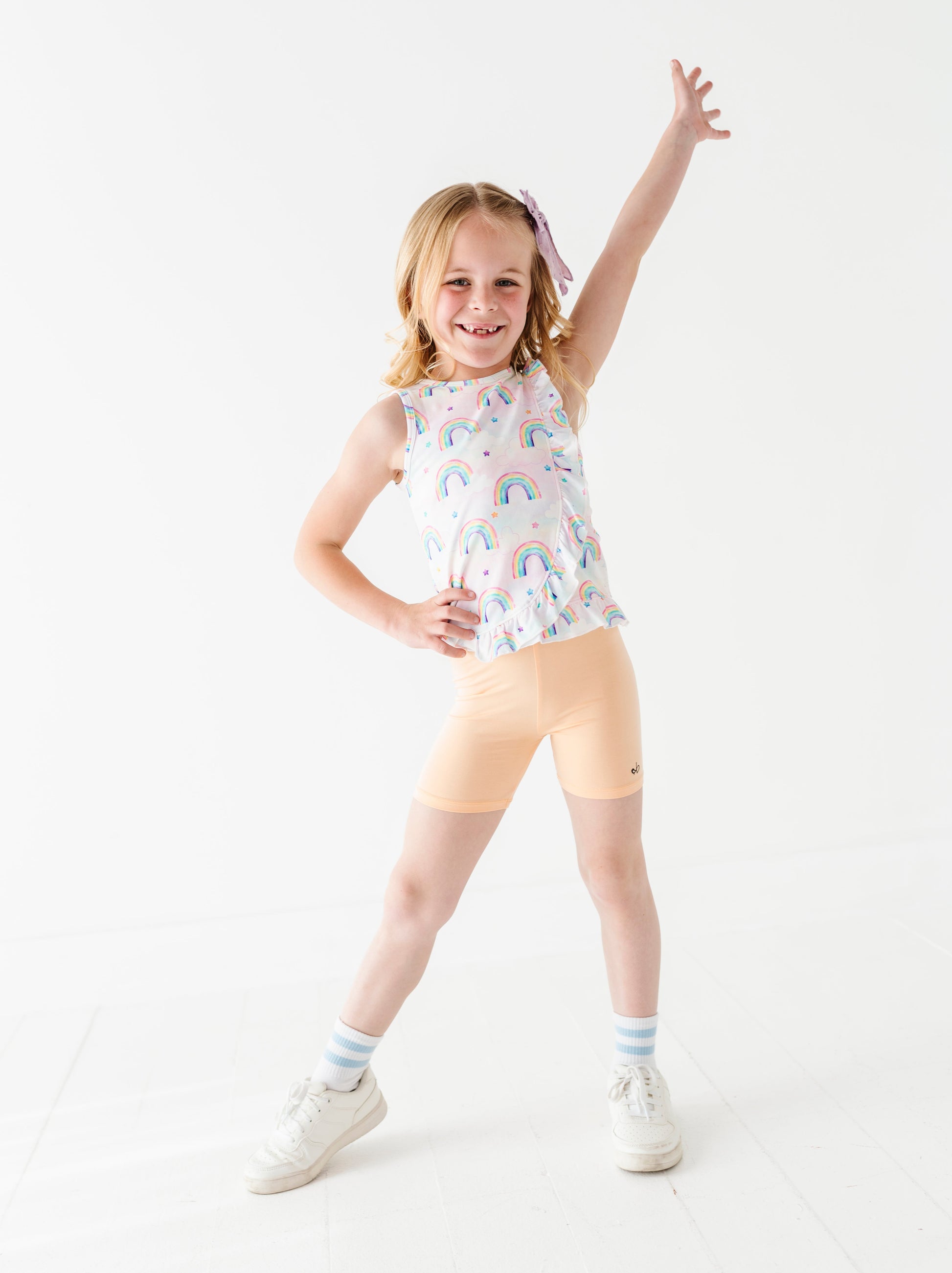 Young girl in a sleeveless bamboo cotton peplum top and bamboo biker shorts posing on a white background