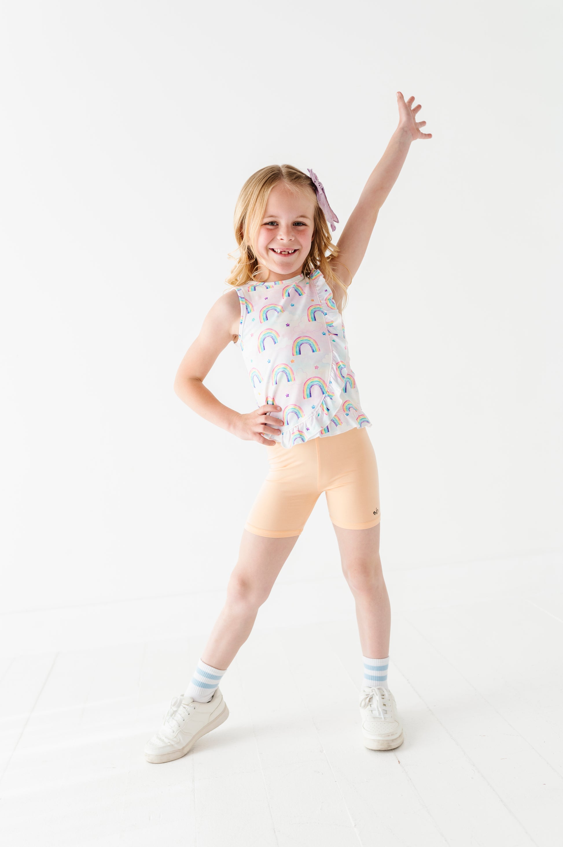 Young girl in a bamboo cotton peplum top and bamboo biker shorts posing on a white background