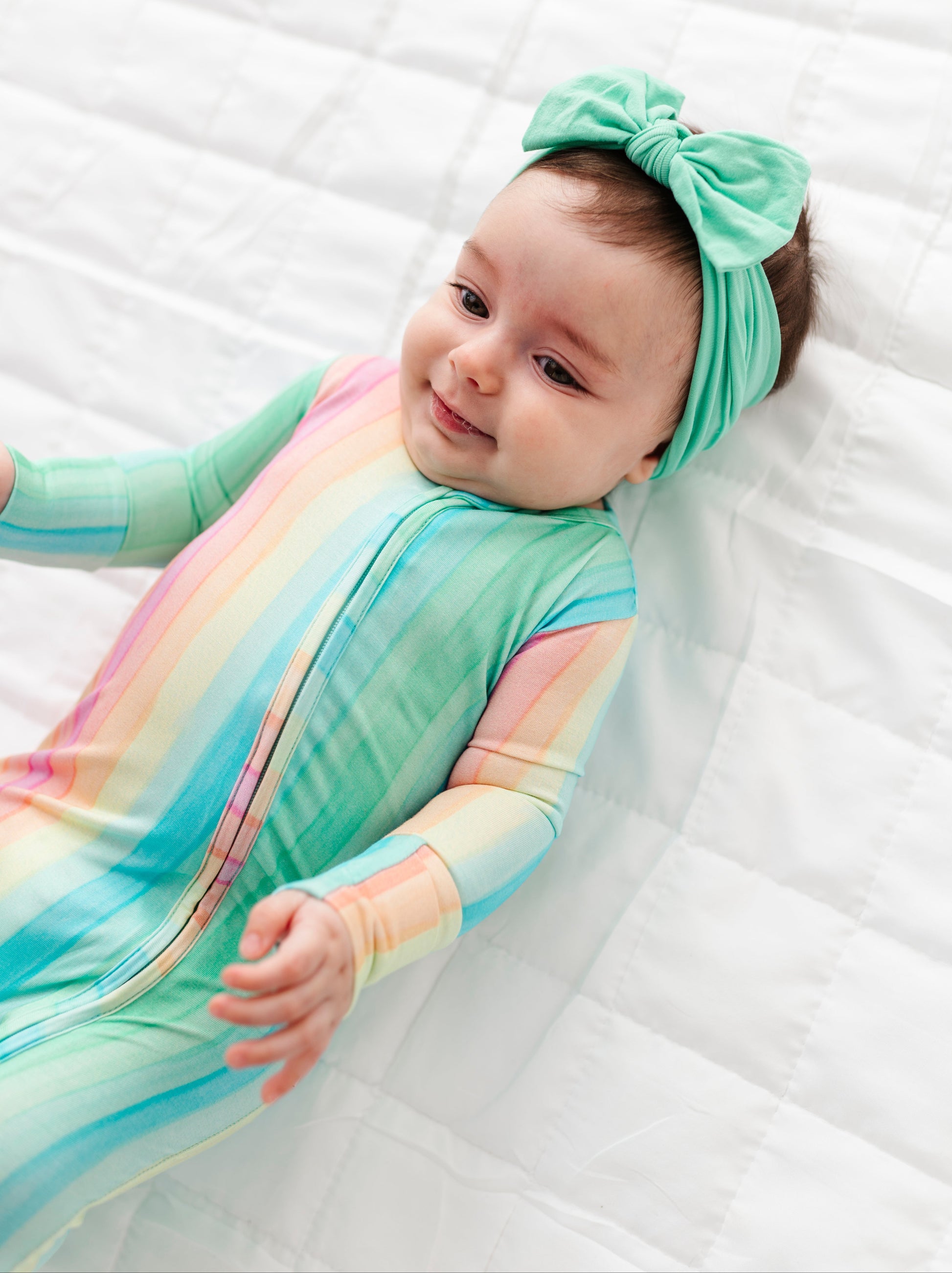 Newborn in colorful rainbow stripe bamboo zip romper designed for sensitive skin and all day comfort