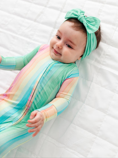 Newborn in colorful rainbow stripe bamboo zip romper designed for sensitive skin and all day comfort