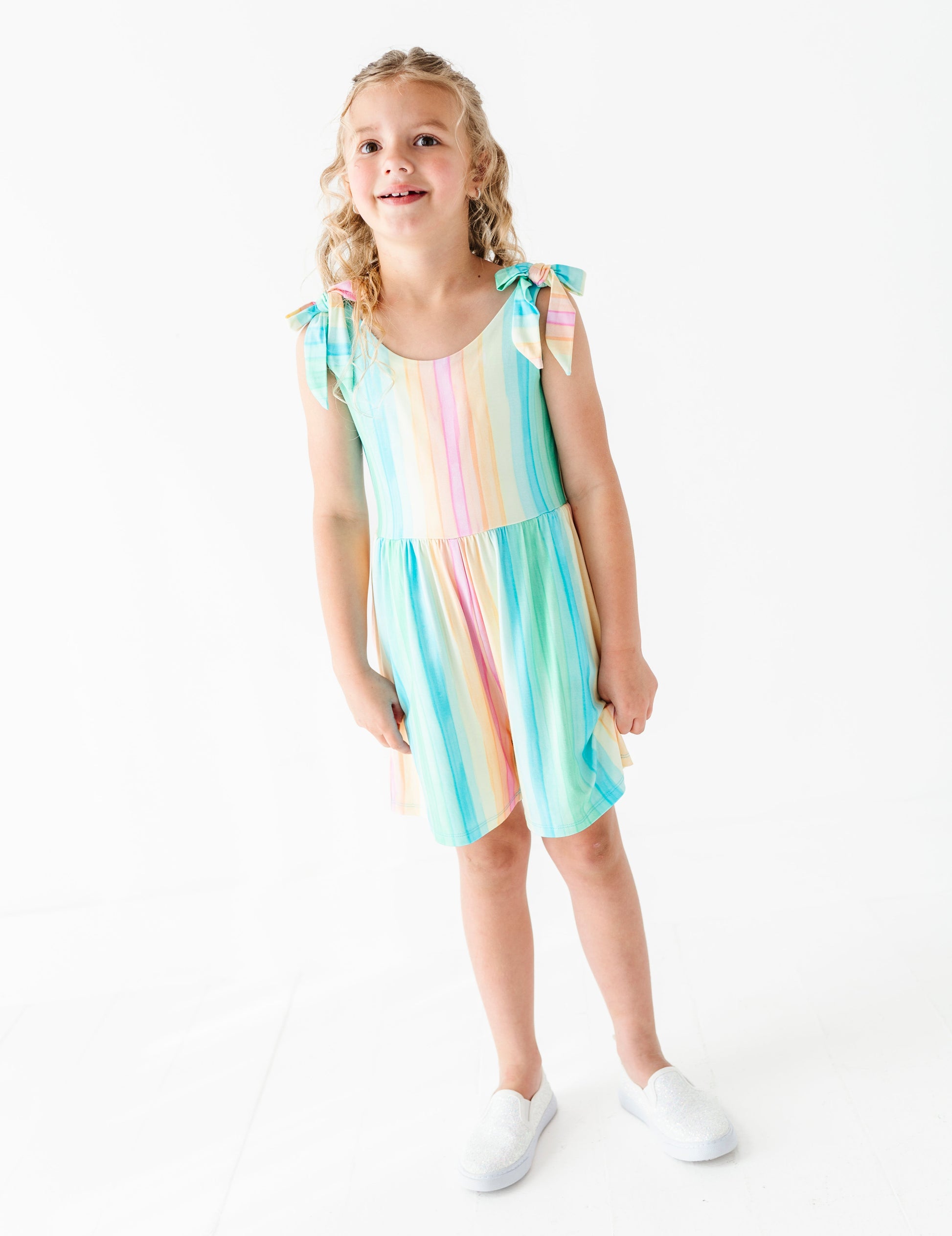 Young girl wearing a colorful romper on a white background