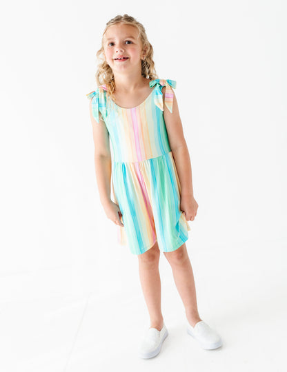 Young girl wearing a colorful romper on a white background