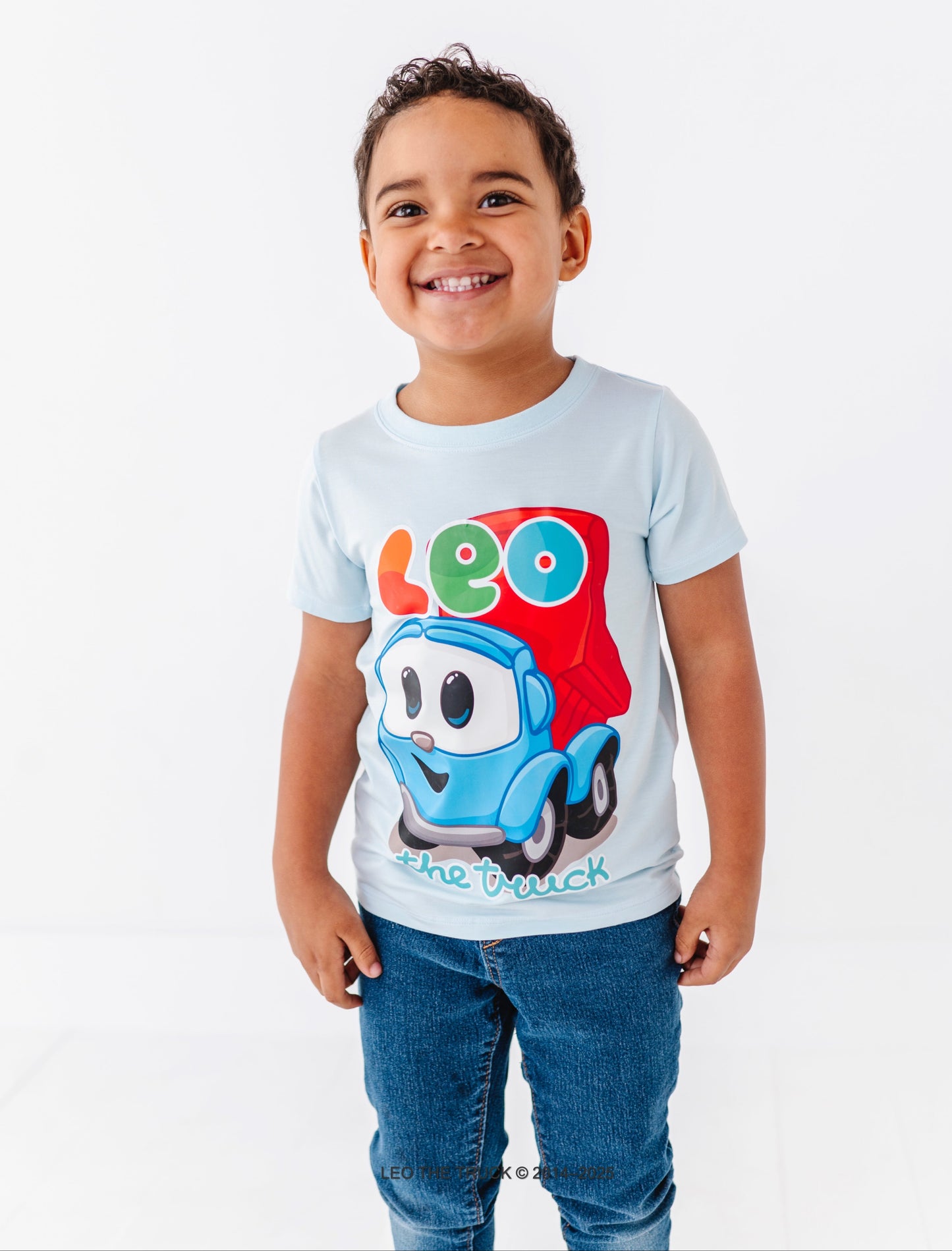 Child wearing a light blue bamboo Leo the Truck t-shirt on a white background