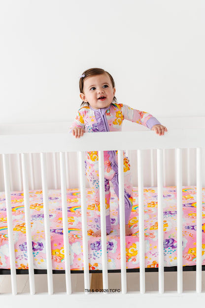 Child in a crib with colorful Care Bears™ bamboo bedding and a white background
