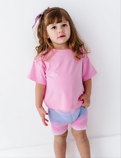 Young girl wearing a pink bamboo outfit with a white background