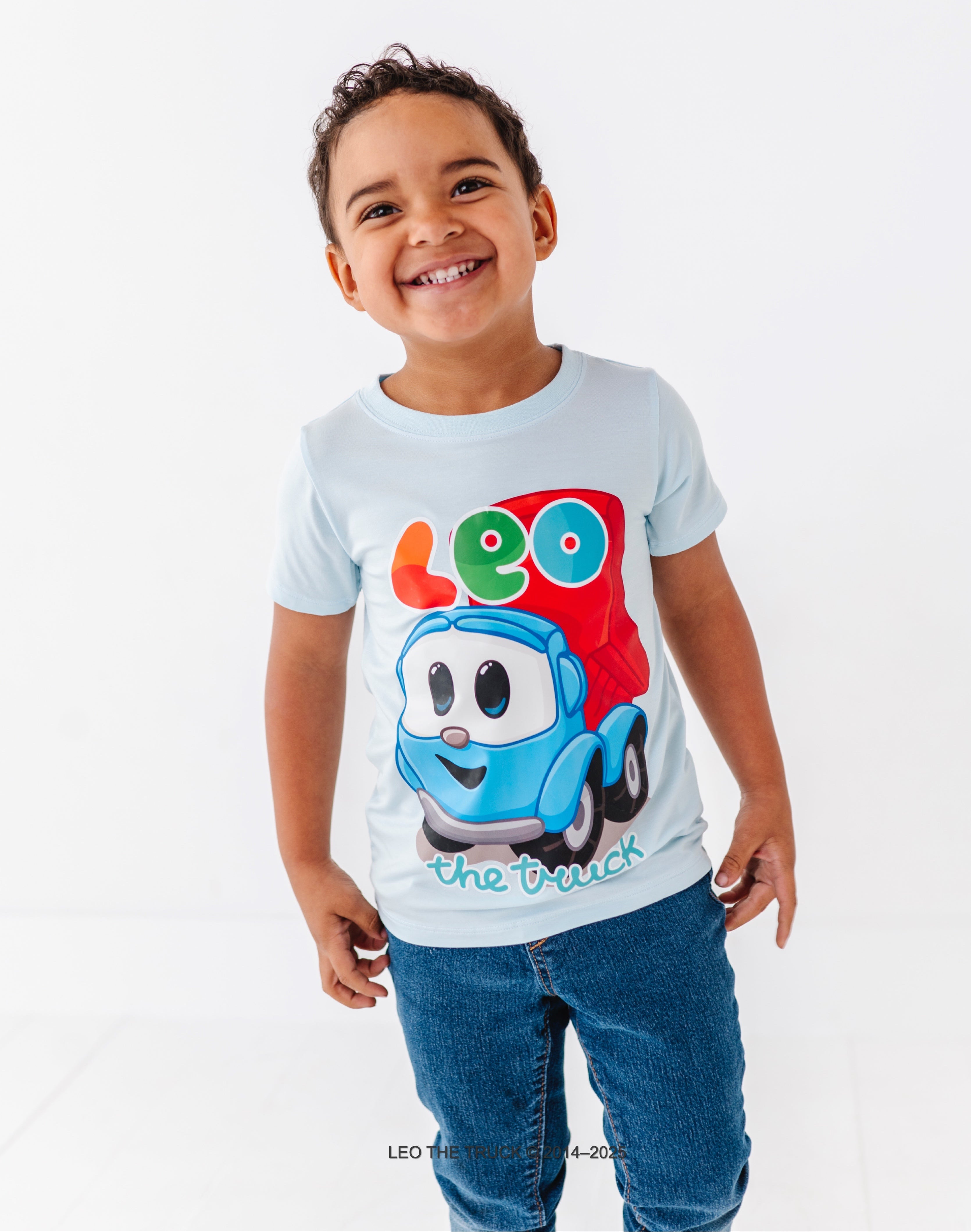 Child wearing a light blue bamboo t-shirt with Leo the Truck graphic against a white background