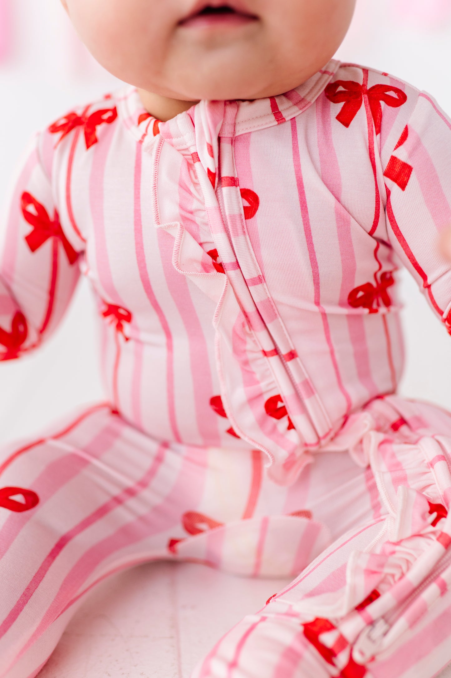 Detail shot of Ruby Ribbons romper zipper and ruffle trim on bamboo fabric
