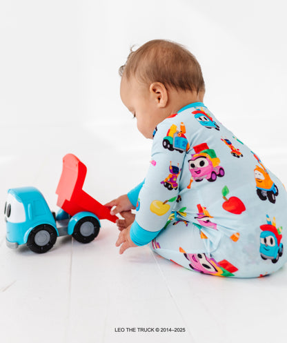 Baby playing with a toy truck wearing a colorful Leo the Truck bamboo onesie on a white background