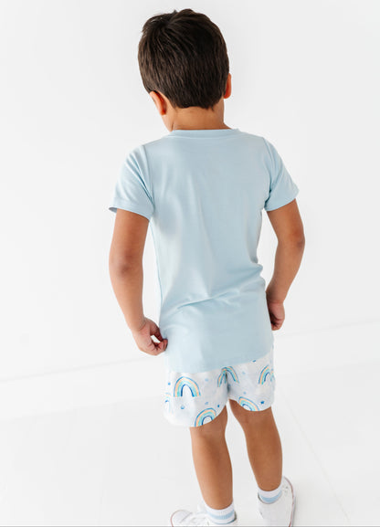 Child wearing a light blue bamboo t-shirt and patterned bamboo cotton shorts on a white background