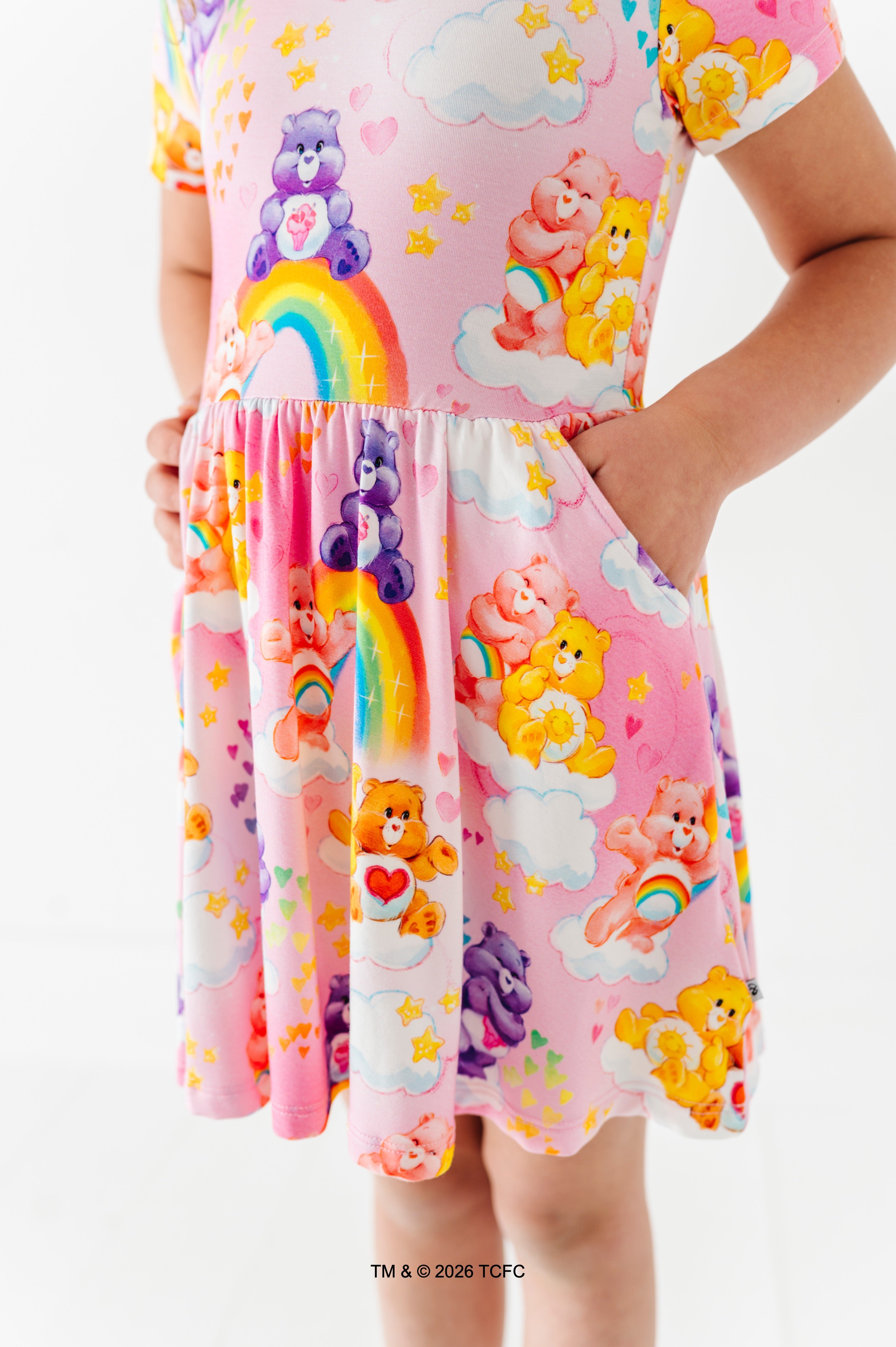 Child wearing a colorful dress with cartoon characters on a white background