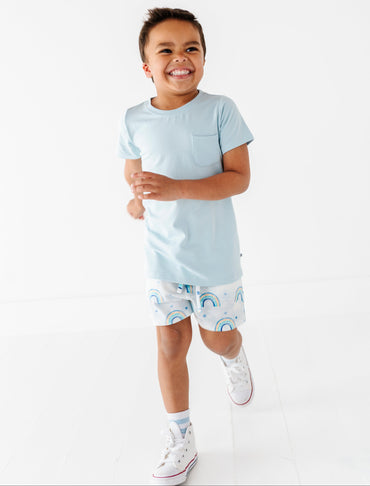 Child wearing a light blue bamboo t-shirt and patterned bamboo cotton shorts on a white background
