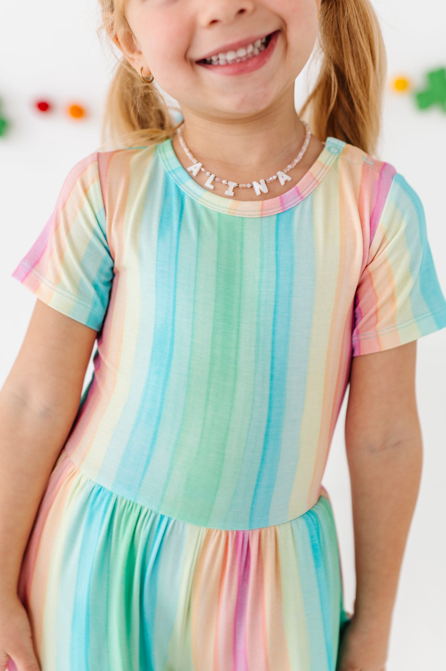 Close-up of rainbow stripe bamboo jumpsuit fabric with pastel vertical stripes