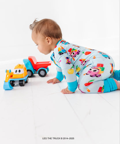 Baby boy playing with Leo the Truck toys wearing a matching Leo the Truck bamboo zip romper
