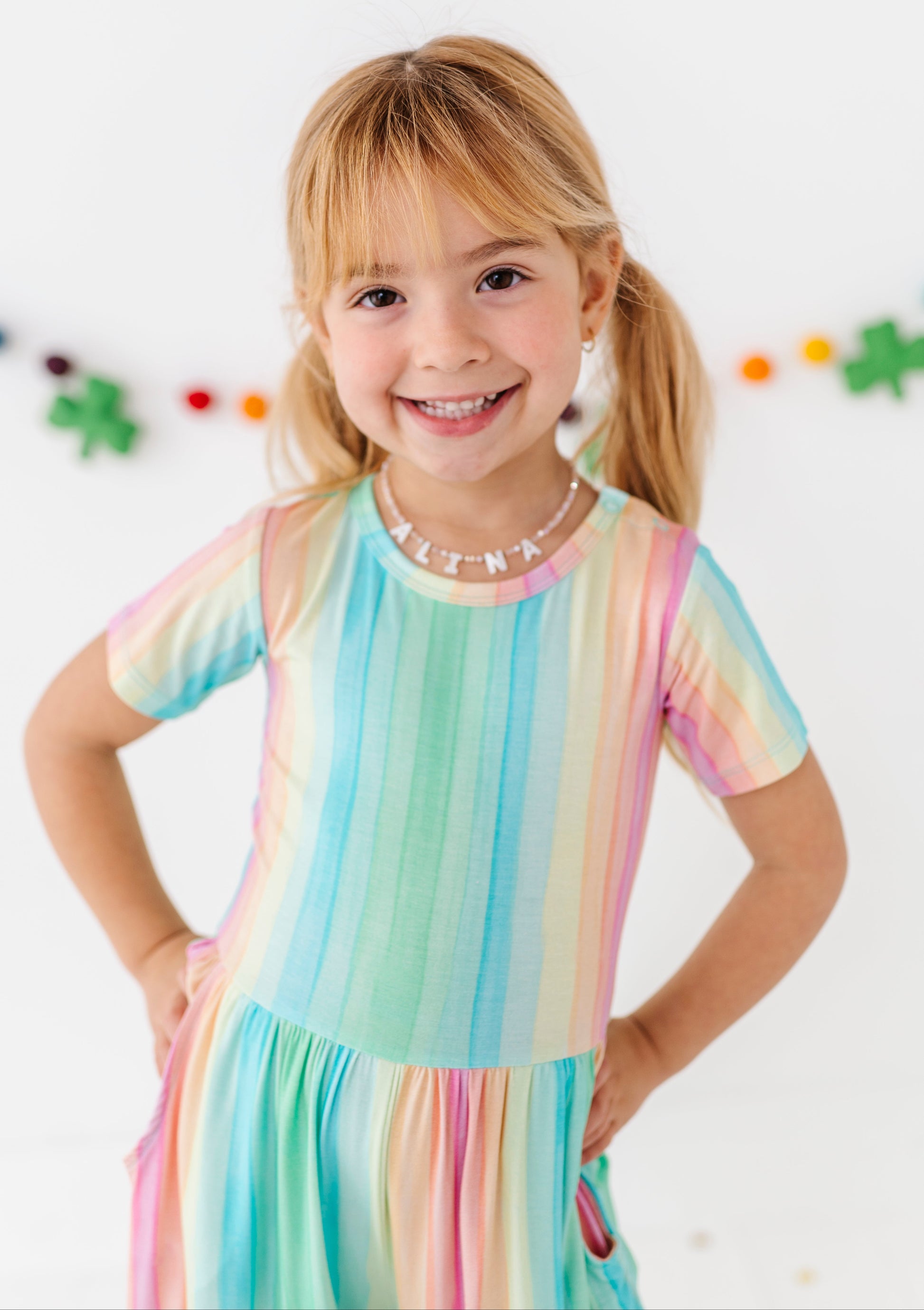 Toddler wearing a rainbow stripe jumpsuit with relaxed fit and breathable bamboo material
