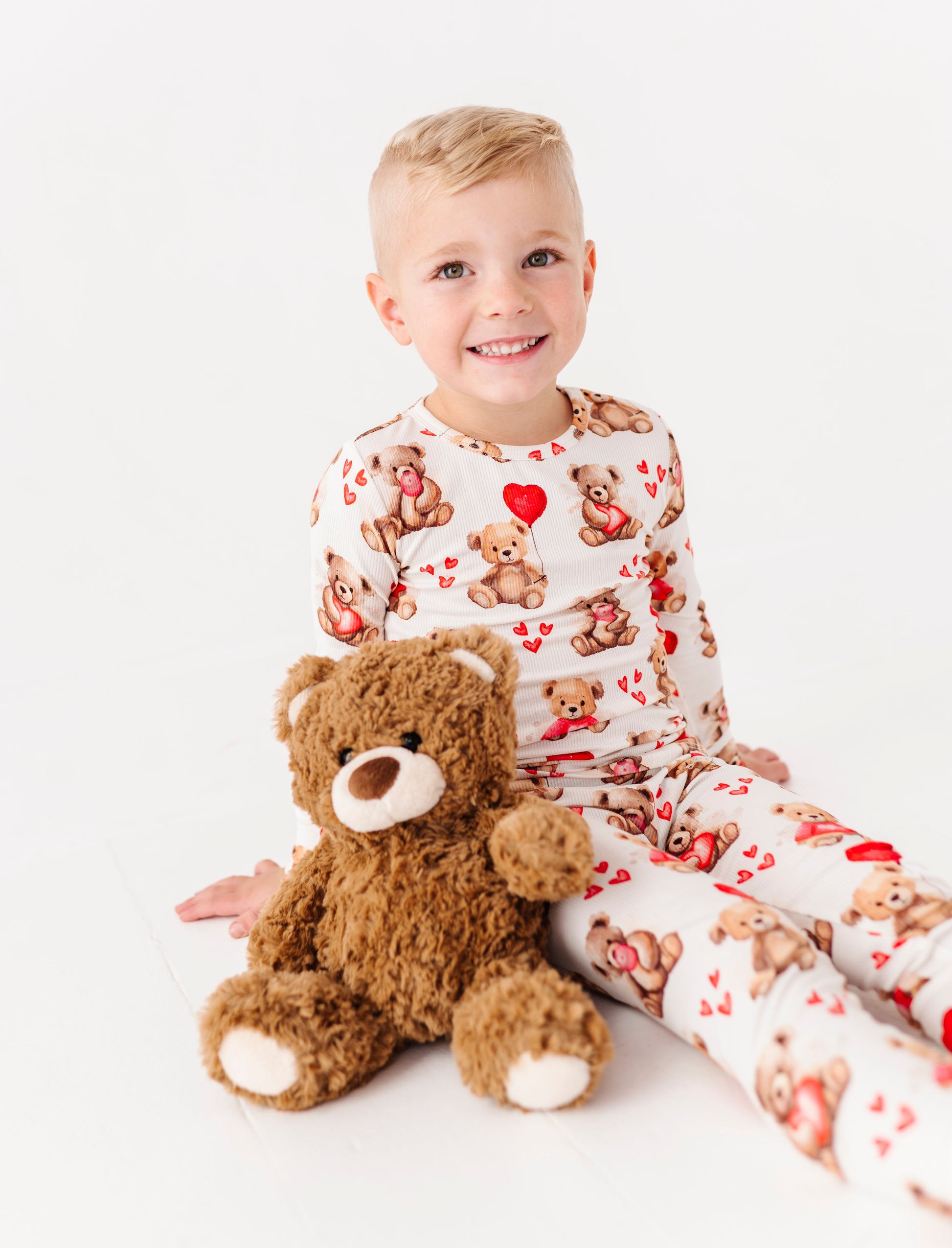 Child lounging in Beary Sweet ribbed bamboo pajamas on white studio background