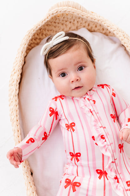 Baby girl in pink striped bamboo romper with red ribbon bows and front ruffle