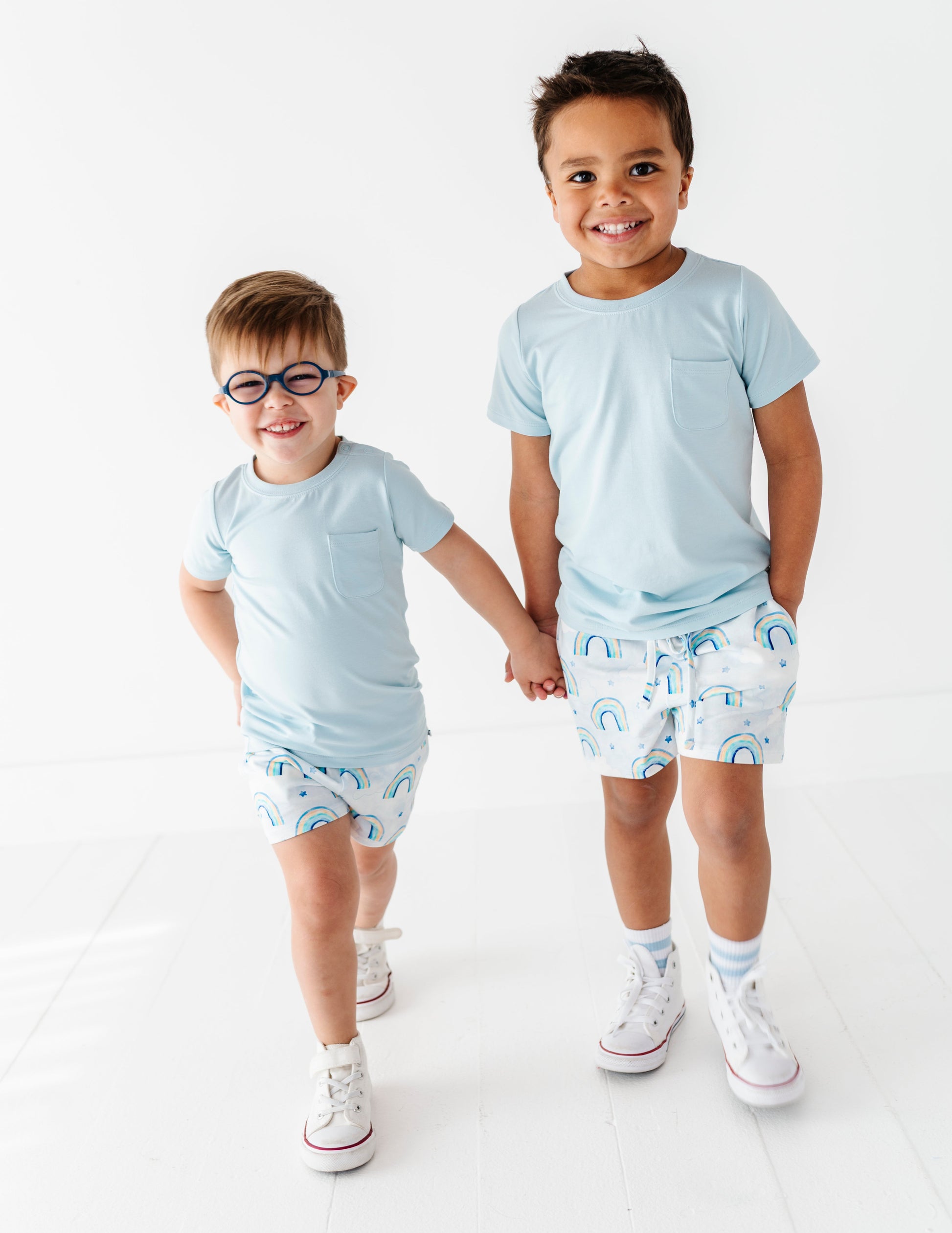 Two children wearing matching light blue bamboo t-shirts and bamboo cotton shorts with a white background