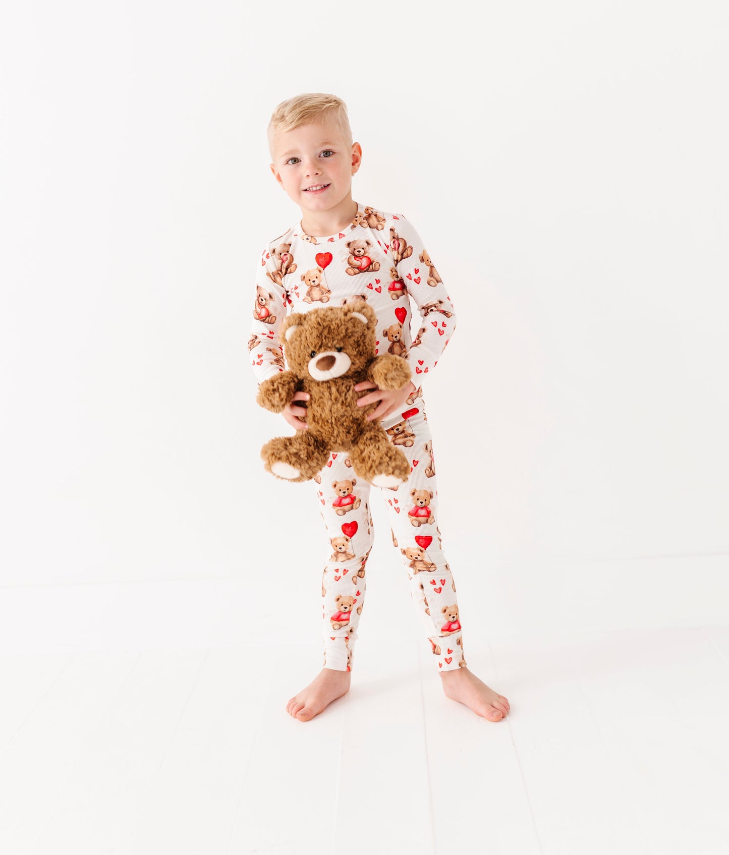 Toddler in Beary Sweet bamboo two-piece pajamas holding a plush teddy bear