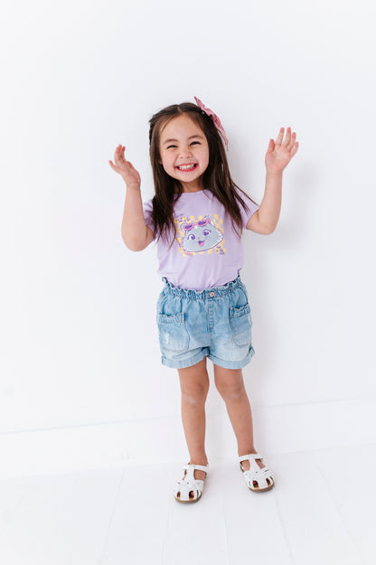 Child wearing a purple t-shirt with a graphic design featuring Milady from 44 Cats and denim shorts on a white background