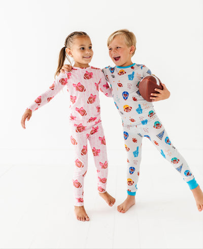 Two children wearing patterned pajamas on a white background