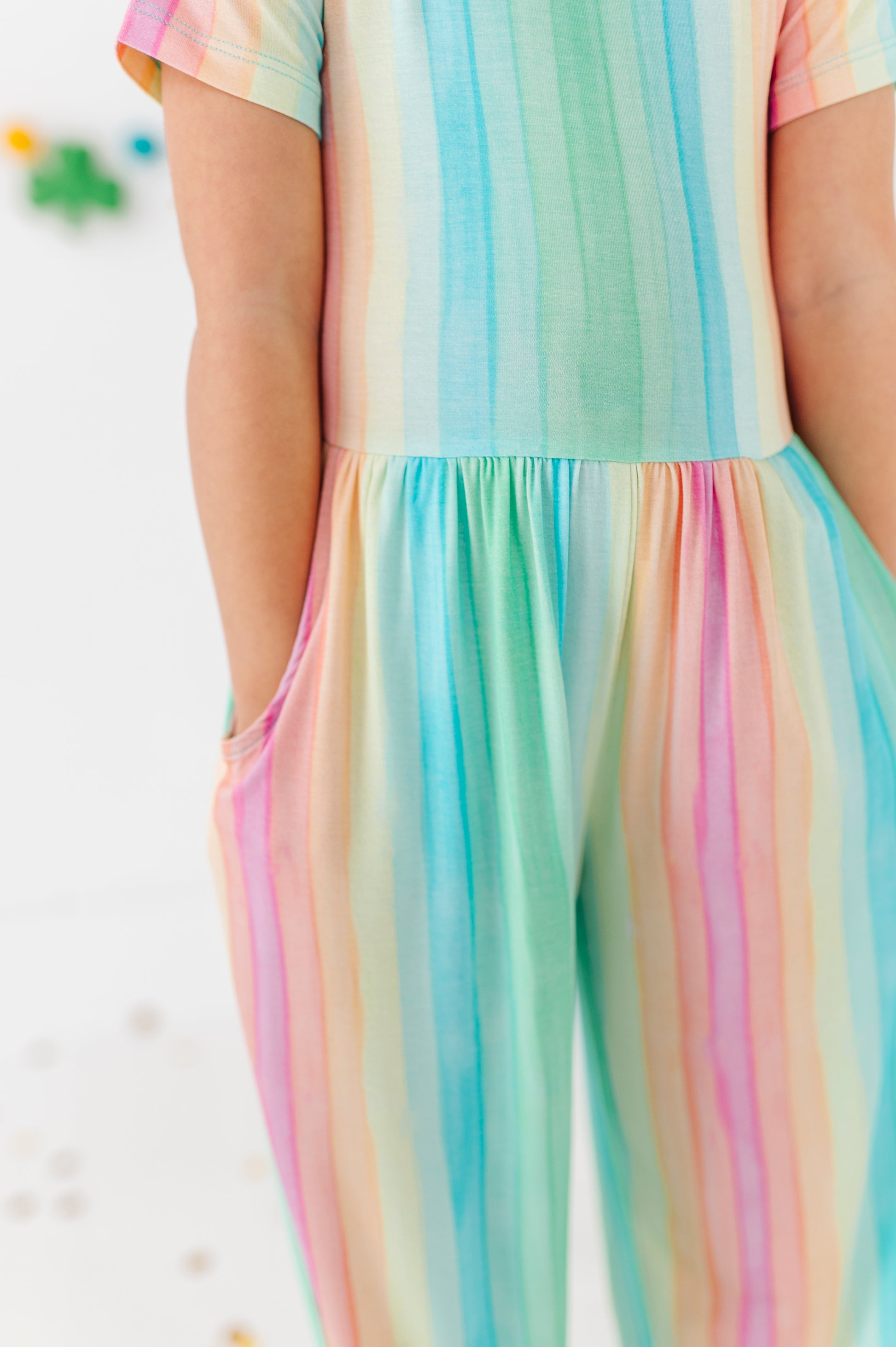 Detail view of rainbow stripe jumpsuit showing soft bamboo viscose texture