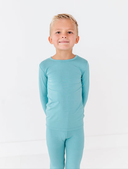 Child wearing slate bamboo two-piece pajamas on white background
