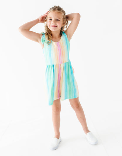 Young girl wearing a colorful romper on a white background