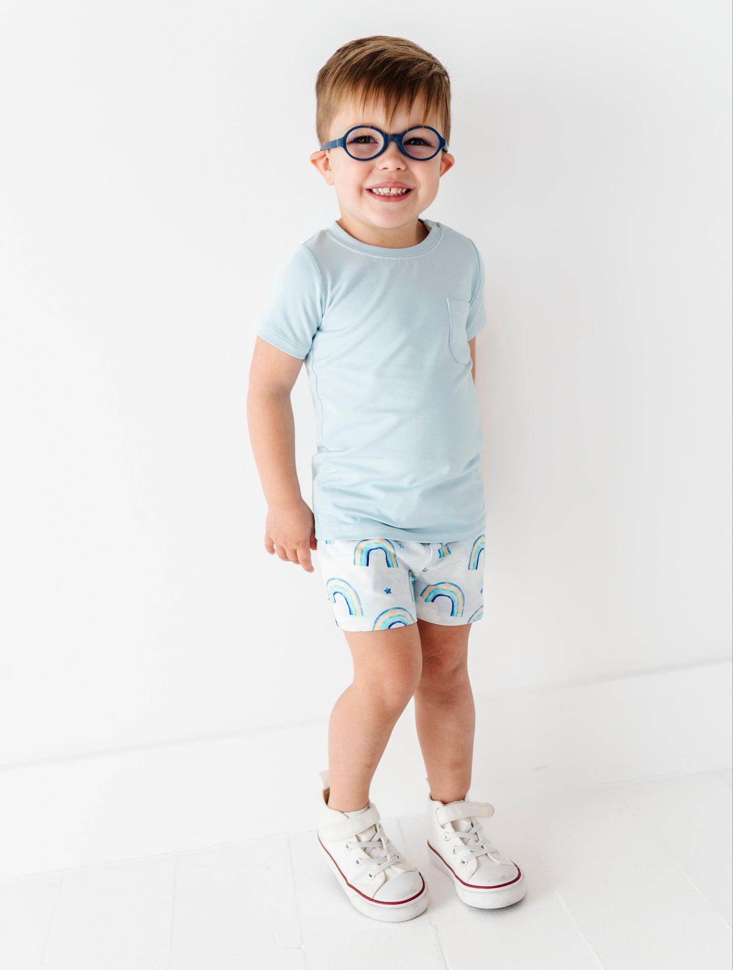 Child wearing a light blue bamboo t-shirt and patterned bamboo cotton shorts on a white background